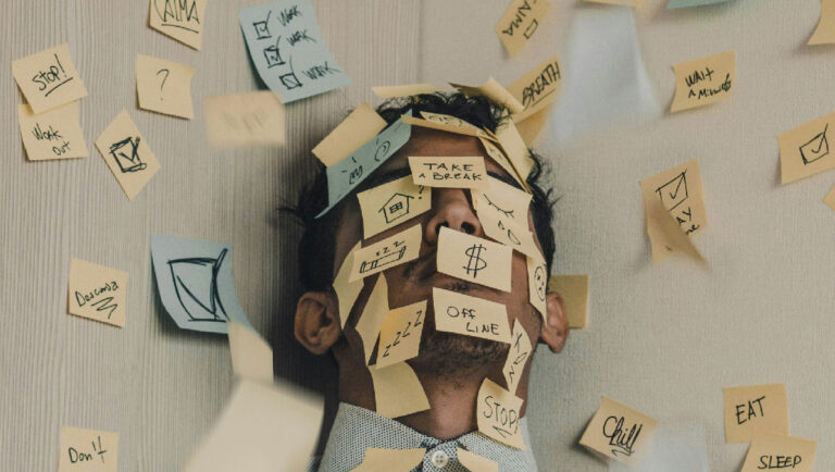 Kopf eines Mannes der mit Post-its bedeckt ist - Symbolbild : Überarbeitung, Stress