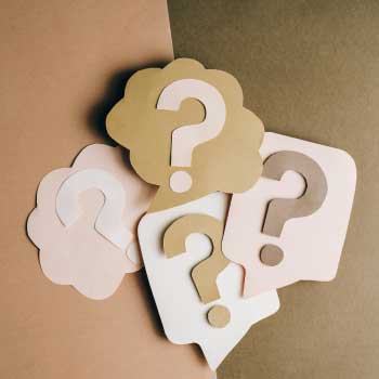 vier Fragezeichen auf braunen Hintergrund