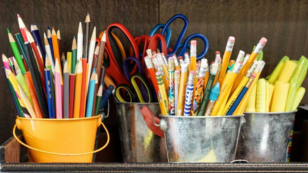 Viele Stifte: Bleistifte, Filzstifte und Scheren auf einem Regal