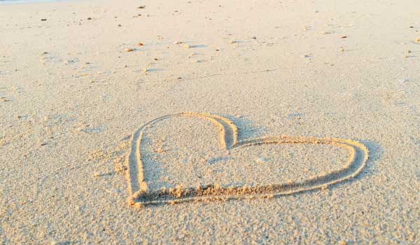 ein in Sand gemaltes Herz. Symbol für Liebe. Achtsamkeit und Selbstmitgefühl 